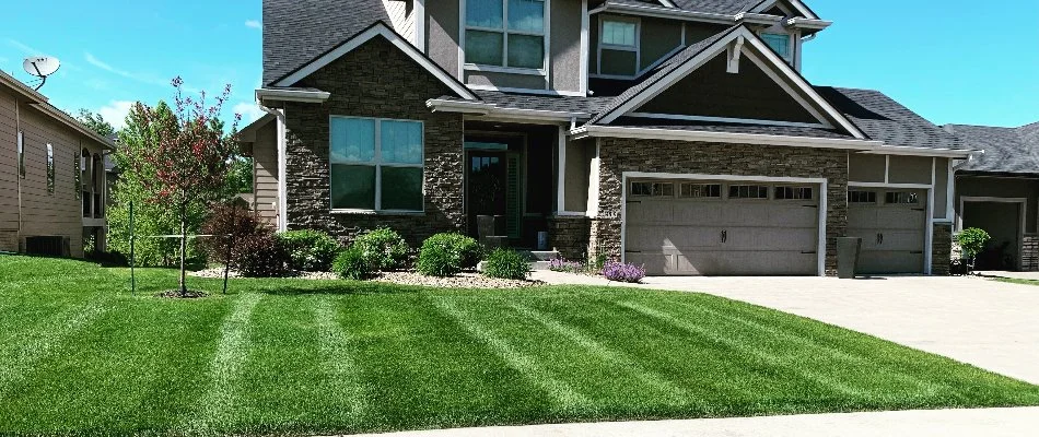 Home with a green lawn and beautiful landscaping in Pleasant Hill, IA.