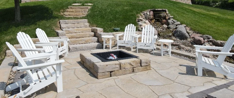 Patio area with a fire pit and outdoor steps in Pleasant Hill, IA.